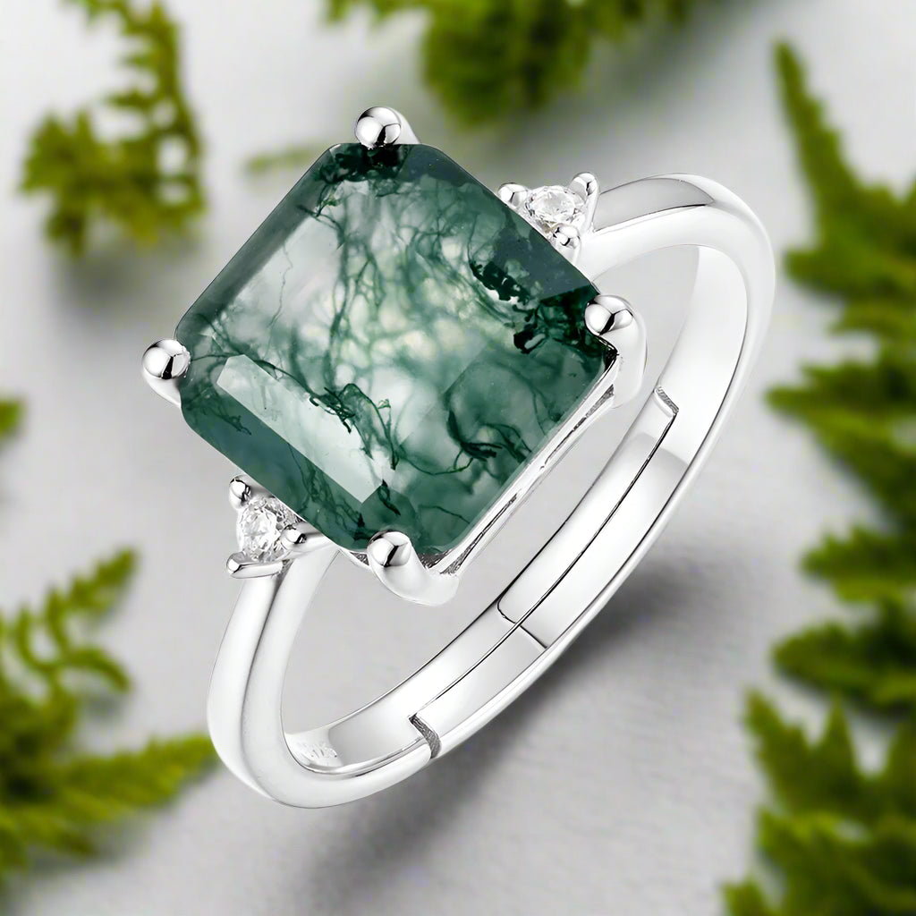 Silver ring with a green gemstone on a white background