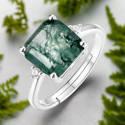 Silver ring with a green gemstone on a white background