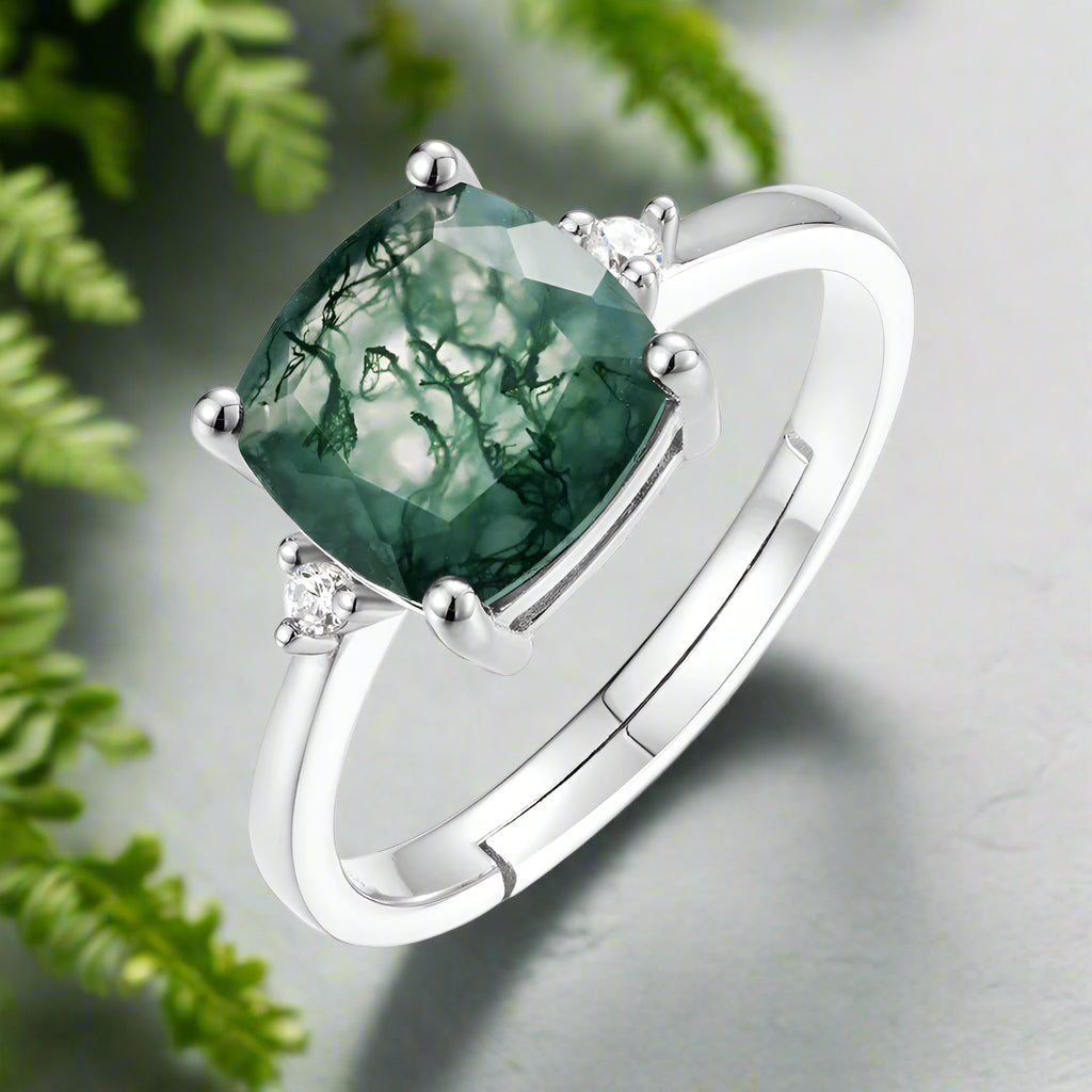 Silver ring with a green gemstone on a white background