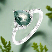Silver ring with a green gemstone on a white background