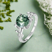 Silver ring with a green gemstone on a white background