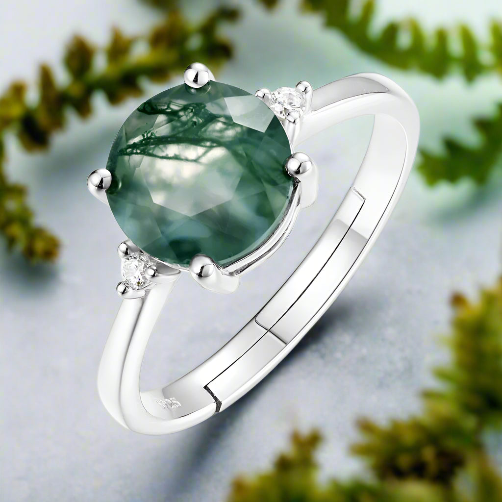 Silver ring with a green gemstone on a white background