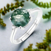 Silver ring with a green gemstone on a white background