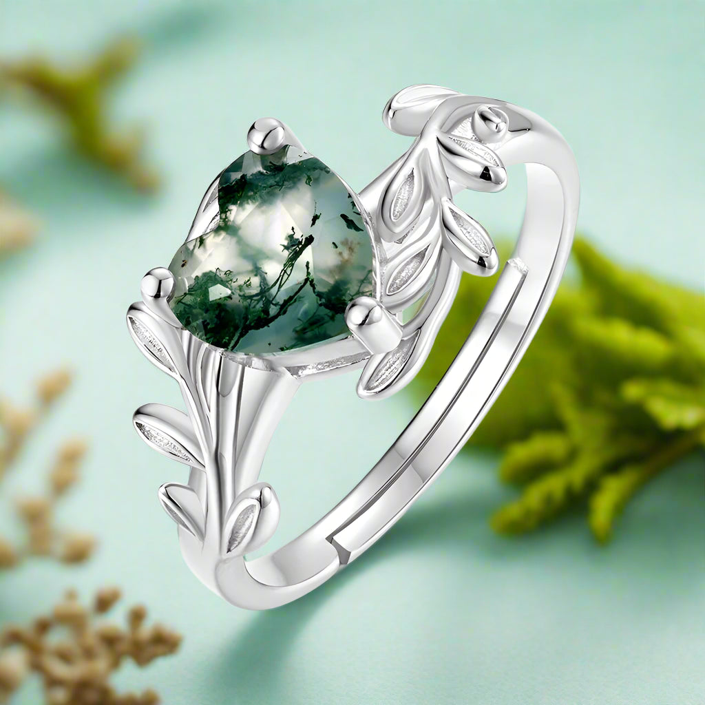 Silver ring with a green gemstone on a white background