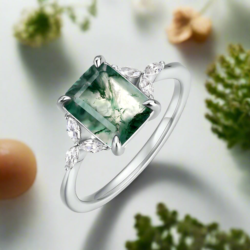 Silver ring with a green gemstone on a white background