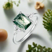 Silver ring with a green gemstone on a white background