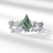 Silver ring with a green gemstone on a white background