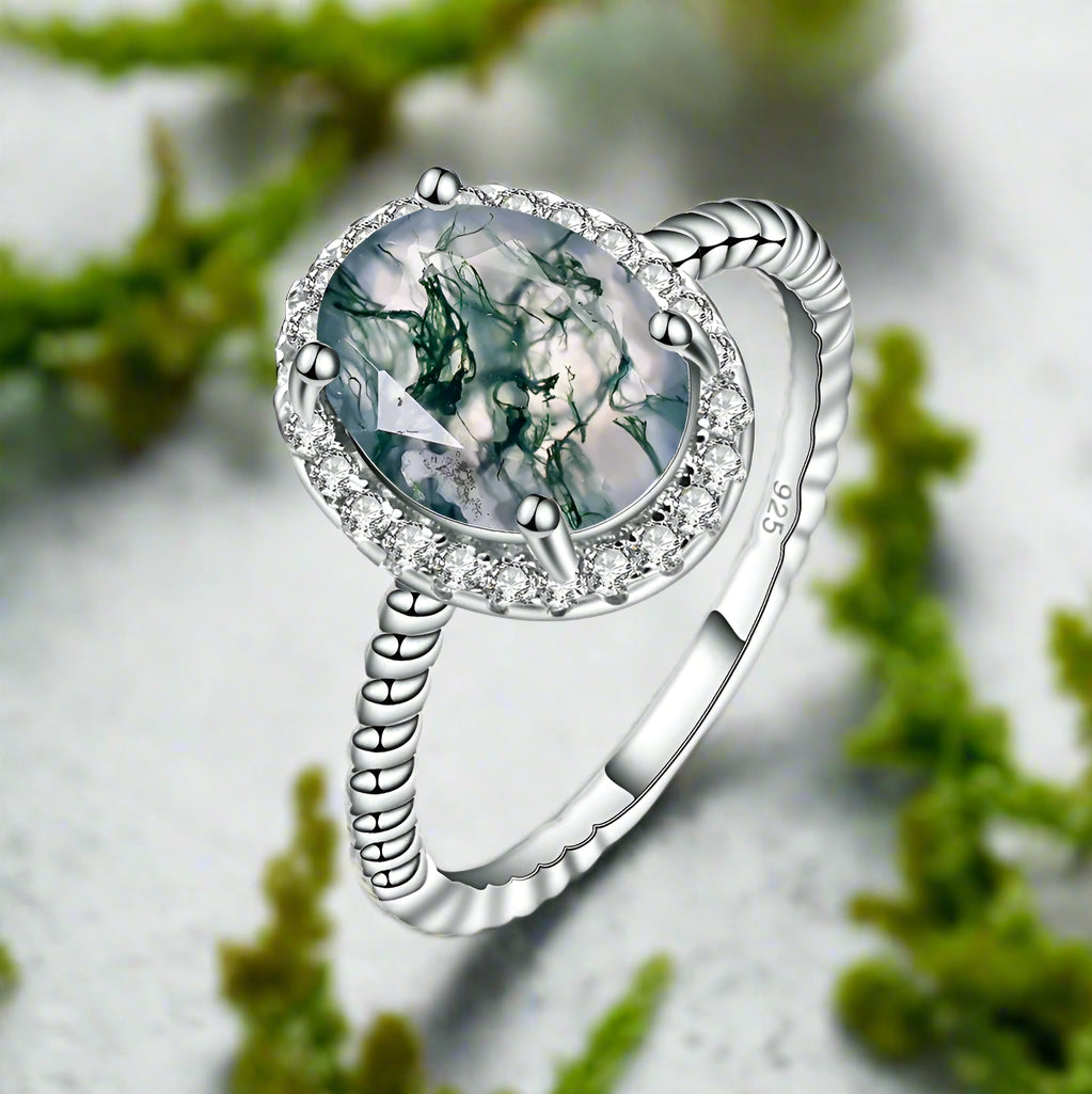 Silver ring with a green gemstone on a white background