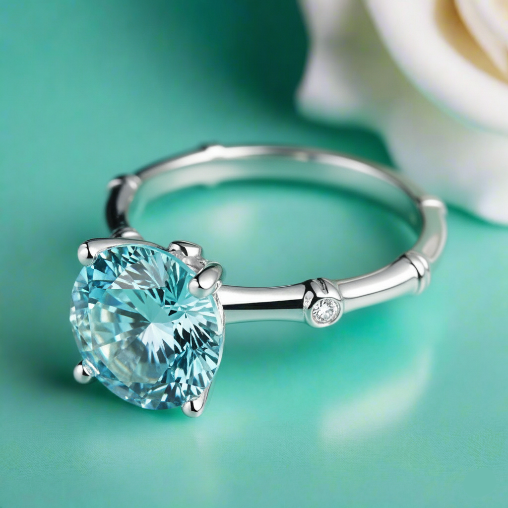Silver ring with a large blue gemstone on a teal background