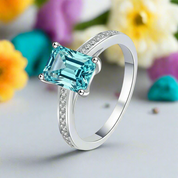 Silver ring with a large blue gemstone on a white background