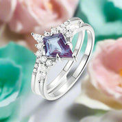 Silver ring with a purple gemstone and diamonds on a white background 