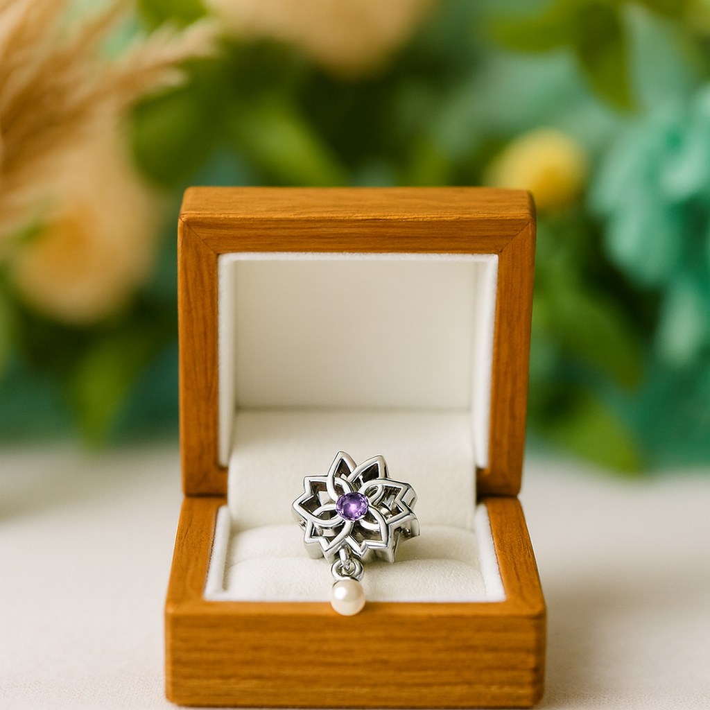 Silver ring with a purple gemstone and pearl in a wooden box against a blurred natural background