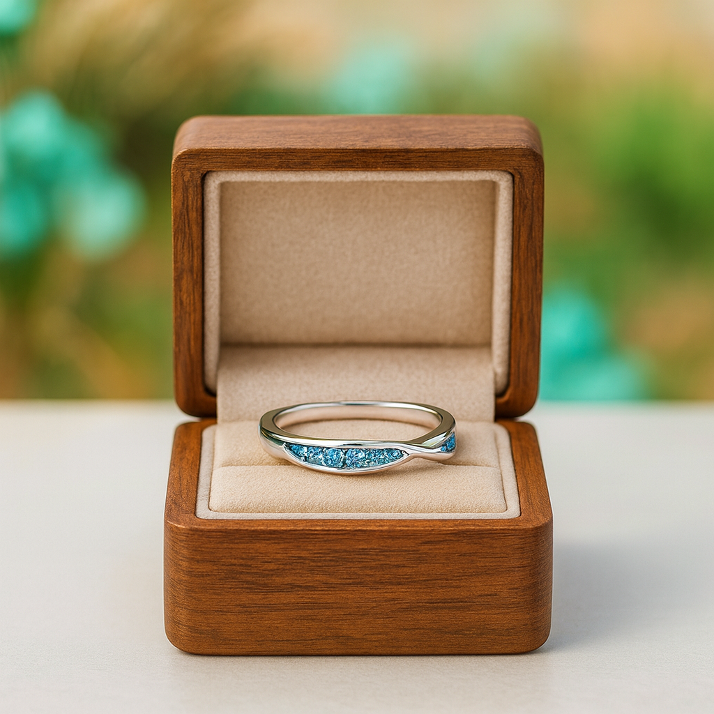 Silver ring with blue gemstones in a wooden box against a blurred natural background