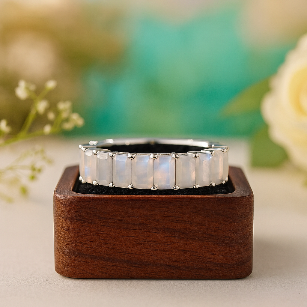 Silver ring with opal stones on a wooden stand against a blurred floral background