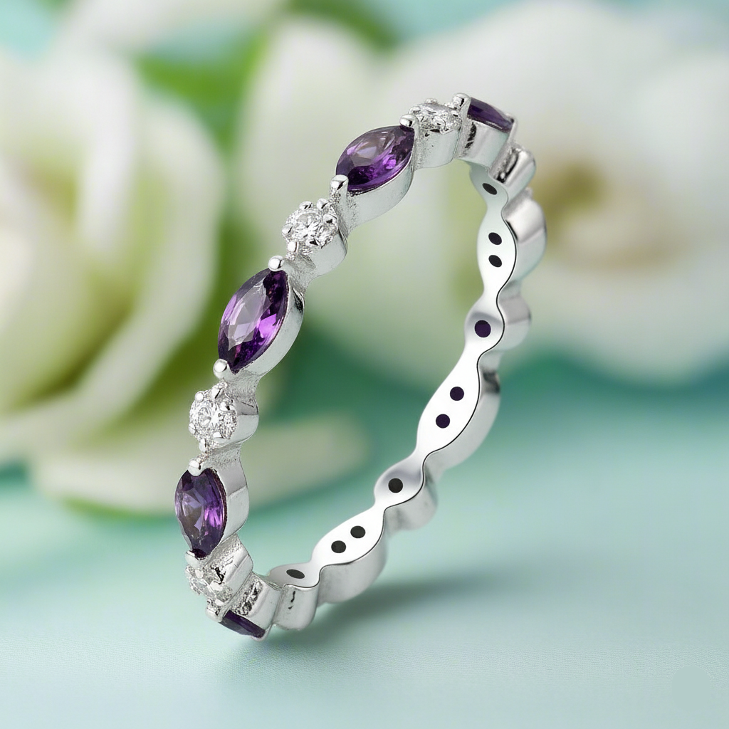 Silver ring with purple gemstones on a light green background