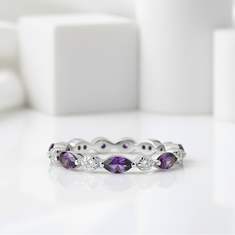 Silver ring with purple gemstones on a light green background