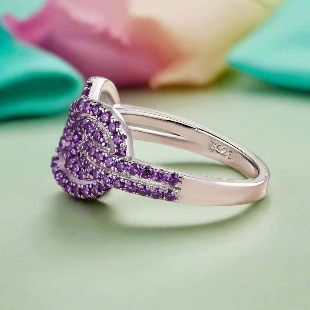 Silver ring with purple gemstones on a light green background