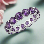 Silver ring with purple gemstones on a white background