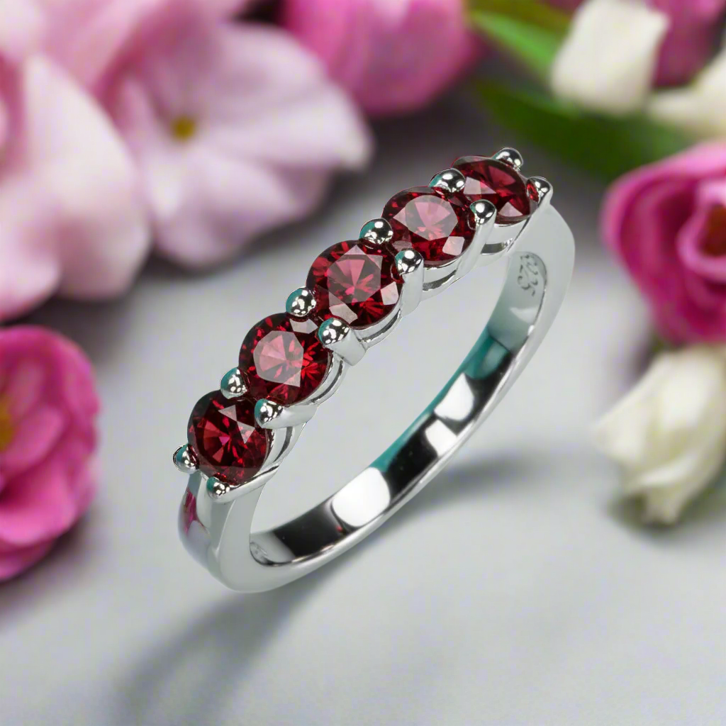 Silver ring with red gemstones on a light blue background
