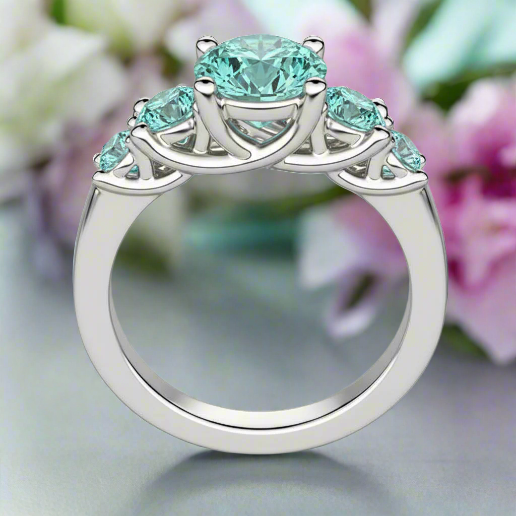 Silver ring with turquoise gemstones on a white background