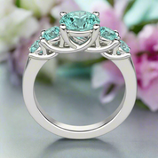 Silver ring with turquoise gemstones on a white background