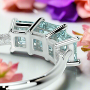 Silver ring with two princess-cut blue gemstones on a white background
