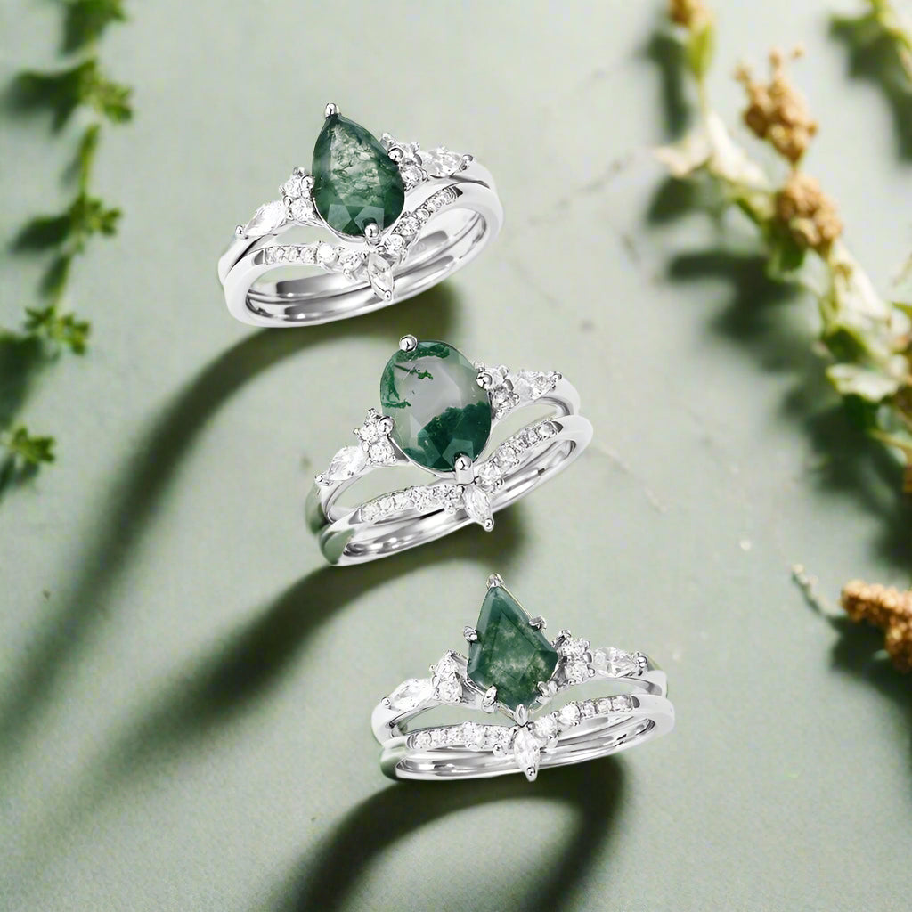 Three silver rings with green gemstones on a white background