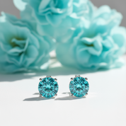 Turquoise gemstone earrings with silver settings on a white background