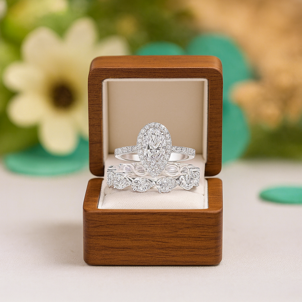 Two diamond rings in a wooden box with a floral background