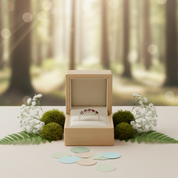 Wooden jewelry box with a ring inside, surrounded by flowers and leaves in a forest setting