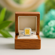 Yellow diamond ring in a wooden box with a blurred green background