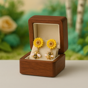 Yellow sunflower earrings with bee designs in a wooden box against a blurred natural background
