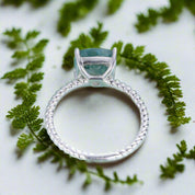 Silver ring with a blue gemstone on a light blue background
